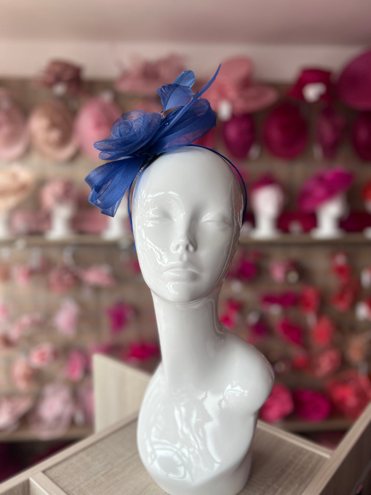 Royal blue fascinator with sinamay loops, cream flower and netting store on a headband!